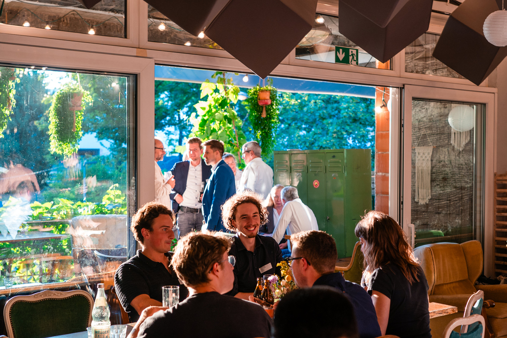 Podiumsdiskussion mit Publikum in einem gemütlichen, dekorierten Veranstaltungsraum.